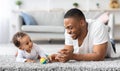 Father-infant bonding. Happy young black dad playing with baby son at home Royalty Free Stock Photo