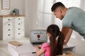 Father installing parental control app on laptop to ensure his child`s safety