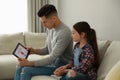 Father installing parental control app on tablet to ensure his child`s safety at home