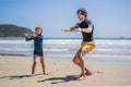Father or instructor teaching his son how to surf in the sea on vacation or holiday. Travel and sports with children