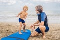 Father or instructor teaching his 4 year old son how to surf in Royalty Free Stock Photo