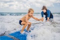 Father or instructor teaching his 4 year old son how to surf in