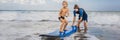 Father or instructor teaching his 4 year old son how to surf in the sea on vacation or holiday. Travel and sports with