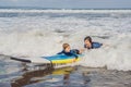 Father or instructor teaching his 5 year old son how to surf in the sea on vacation or holiday. Travel and sports with Royalty Free Stock Photo