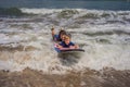 Father or instructor teaching his 5 year old son how to surf in the sea on vacation or holiday. Travel and sports with