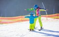 Father or instructor teaching little boy to ski