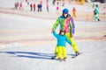 Father ior instructor teaching little boy to ski