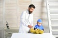 Father and kid with calm faces play doctor
