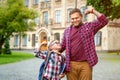 Father and kid have fun. Strong child and dad shows muscles. Parent taking pupil to primary school. Back to school