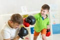 Father and kid play with boxing gloves
