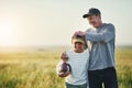 Father, kid smile and rugby ball in a countryside field for bonding and fun in nature. Mockup, dad and young child Royalty Free Stock Photo