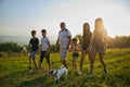 Father with kids and dog walking along field in countryside. Royalty Free Stock Photo