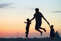 Father and kids jumping at sunset Royalty Free Stock Photo