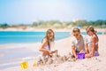 Father and kids making sand castle at tropical beach. Family playing with beach toys Royalty Free Stock Photo