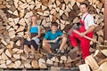 Father and kids prepared to chop firewood and stack it into a wood shed Royalty Free Stock Photo