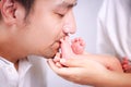 Father is kissing baby`s feet. Happy loving father kisses feet of his newborn baby Royalty Free Stock Photo