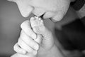 Father kissing foot of newborn baby. Royalty Free Stock Photo