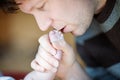 Father kissing foot of newborn baby. Royalty Free Stock Photo