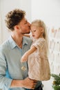 Father kissing his daughter while spending time together near Christmas tree Royalty Free Stock Photo