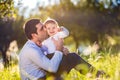 Father kissing his little son, sitting on the grass Royalty Free Stock Photo