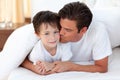 Father kissing his son lying on bed Royalty Free Stock Photo