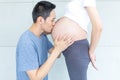 Father kissing pregnant mother`s belly. Man kissing the belly of his lovely pregnant wife