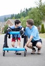 Father kneeling next to son standing in walker Royalty Free Stock Photo