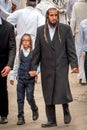 The father leads the son by the hand. The Hasidim pilgrims. Rosh Hashanah, Jewish New Year.