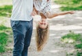 Father letting his laughing daughter fly on his arms