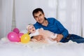 The father lies on the bed hugging his little daughter and holding her by a tiny foot. Baby laughs happily and feels Royalty Free Stock Photo