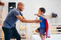 Father lifting son up with super hero costume at home Royalty Free Stock Photo