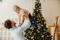 Father lifting up his daughter while spending time together near Christmas tree Royalty Free Stock Photo