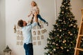 Father lifting up little daughter while spending time together near Christmas tree Royalty Free Stock Photo
