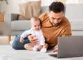 Father With Little Baby Using Laptop Browsing Internet At Home Royalty Free Stock Photo