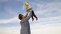 Father and little child play, laugh and hug together. Dad throws up a happy daughter in the blue sky. appy family