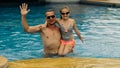 The father with little daughter have fun in the pool. Dad plays with the child. The family enjoy summer vacation in a Royalty Free Stock Photo