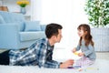 Father and little daughter having quality family time together at home. dad with girl lying on warm floor drawing with colorful Royalty Free Stock Photo