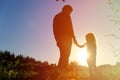 Father and little daughter holding hands at sunset sky Royalty Free Stock Photo