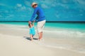 father and little daughter learning to walk on beach Royalty Free Stock Photo