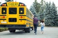 Being Late. Father and daughter following school bus back view waving to driver