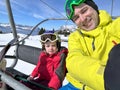 Father and little daughter skiers enjoy sunny ski lift ride Royalty Free Stock Photo