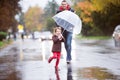 Father with little daughter under umbrella. Walk on rainy day. Royalty Free Stock Photo