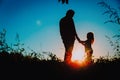 Father with little daughter walk at sunset