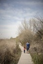 Father and little daughter walking on a path of wooden boards in Royalty Free Stock Photo