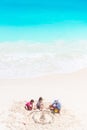 Father and little daughters making sand castle at tropical beach Royalty Free Stock Photo