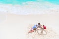 Father and little daughters making sand castle at tropical beach Royalty Free Stock Photo