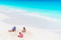 Father and little daughters making sand castle at tropical beach Royalty Free Stock Photo