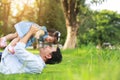 Father and little girl play lying on grass, low angle.