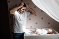 Father and little kid in the nursery. The first year of life. Uncertainty and fear of a child. Daddy does not know what Royalty Free Stock Photo