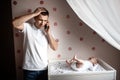 Father and little kid in the nursery. The first year of life. Uncertainty and fear of a child. Daddy does not know what Royalty Free Stock Photo